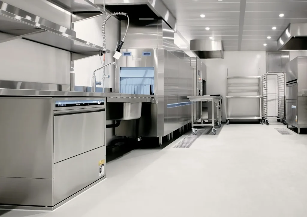 Commercial kitchen with stainless steel sinks and dishwashing plumbing