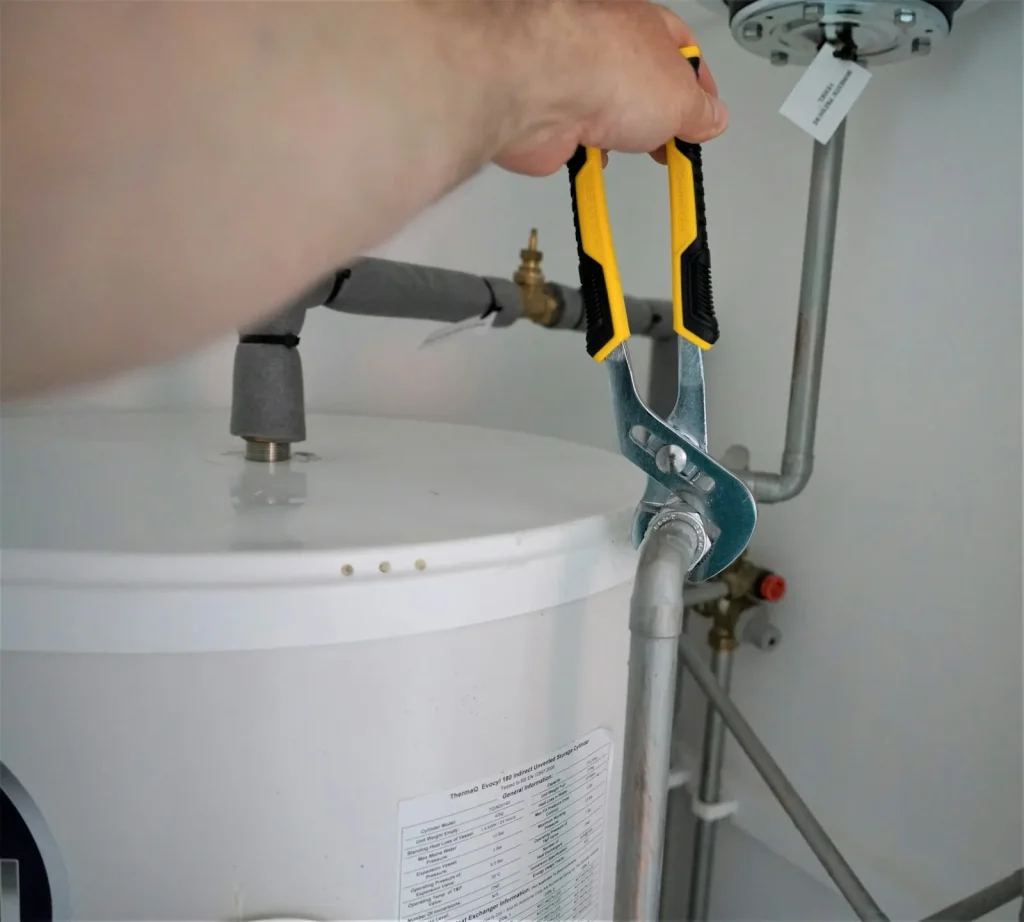 Plumber adjusting the valves on a hot water system
